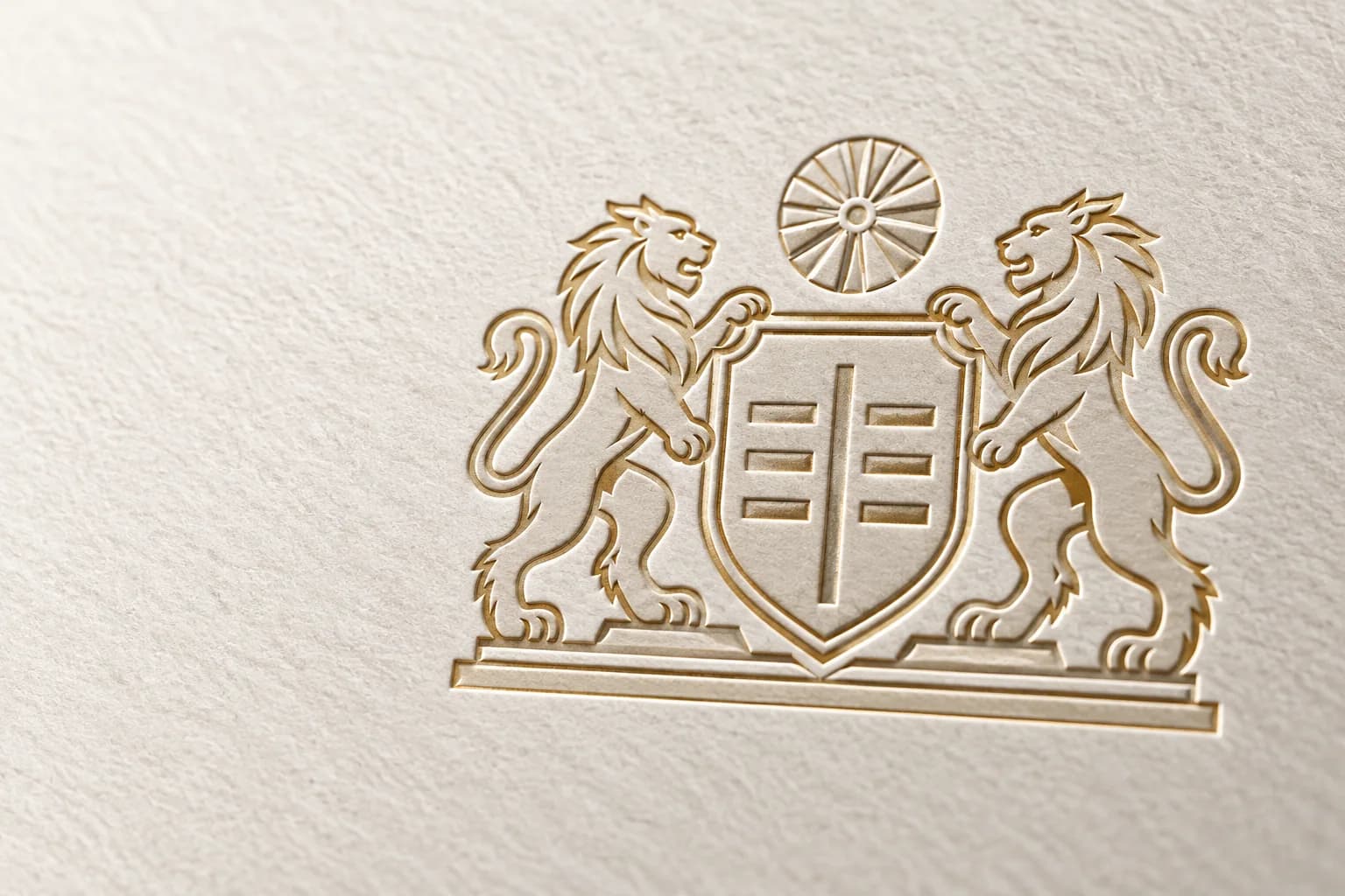 The ISAO crest, two lions either side of a shield below a radial emblem, debossed with gold foil edges into textured cream paper.